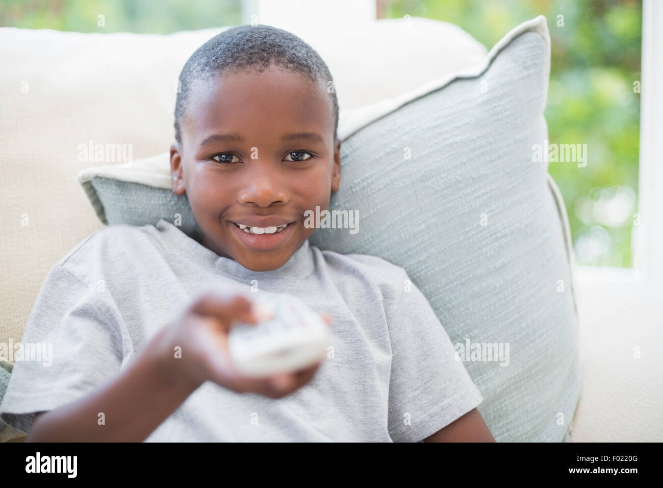 Little Boy guardare la tv sul lettino Foto Stock
