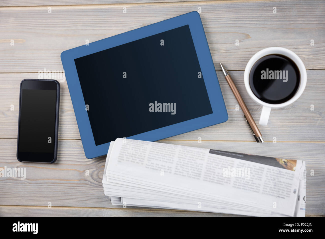 Tablet accanto la tazza di caffè smartphone e giornale Foto Stock