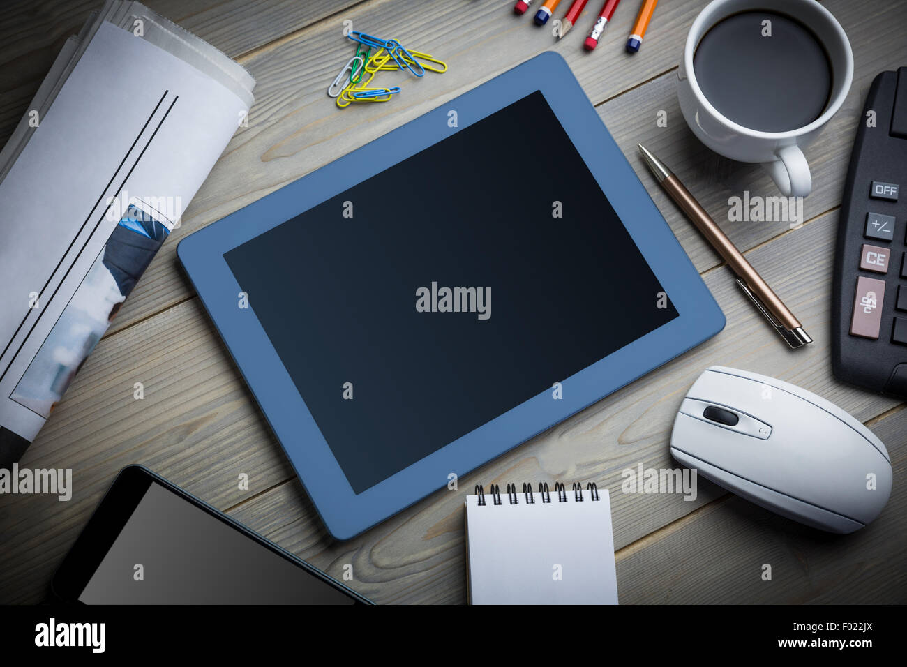 Tablet accanto alla tazza di caffè notepad un computer e uno smartphone Foto Stock