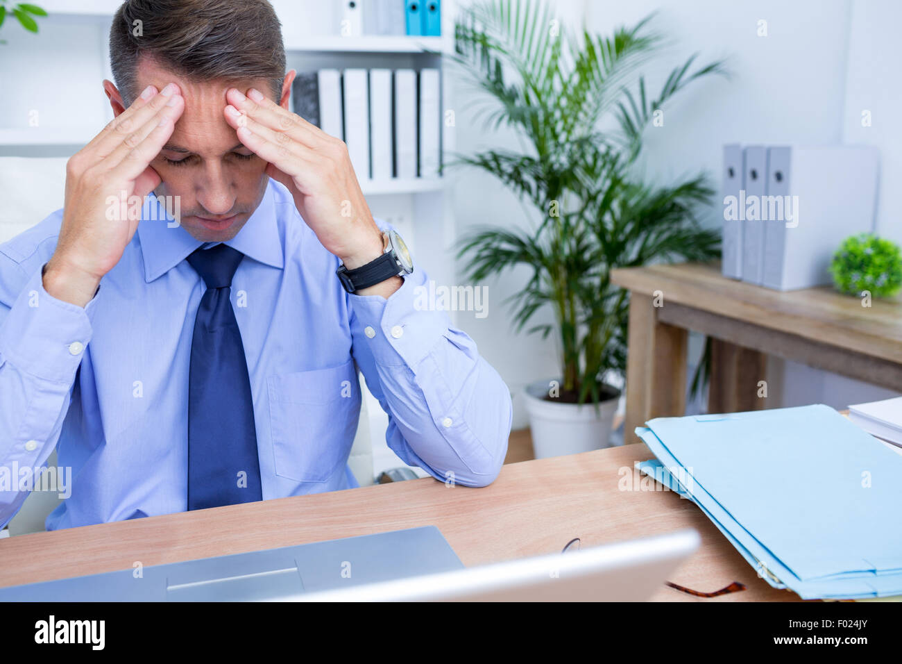 Imprenditore con grave cefalea tenendo la sua testa Foto Stock