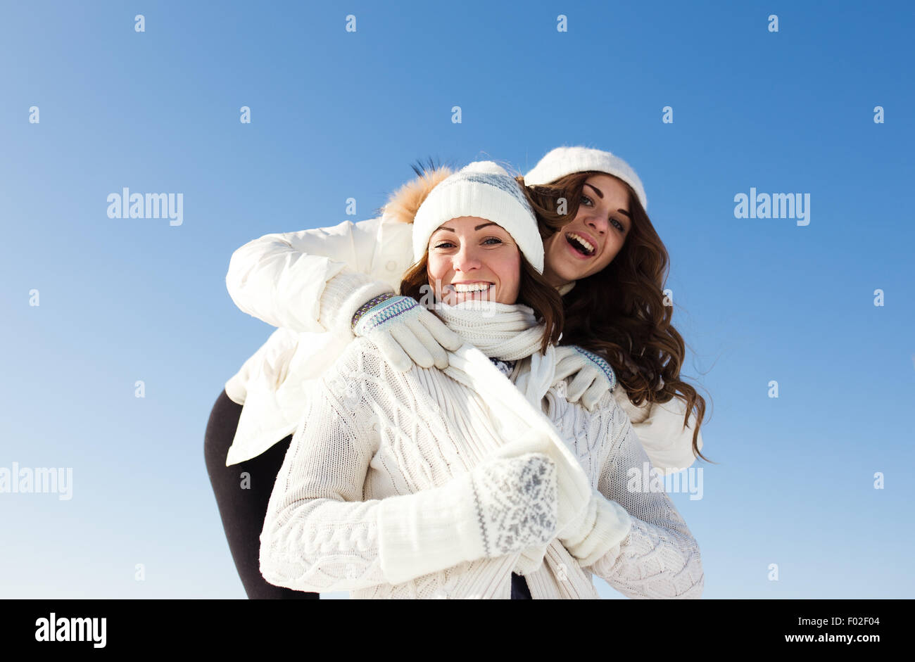 Due amiche divertirsi e godere la neve fresca in un bel giorno di inverno Foto Stock