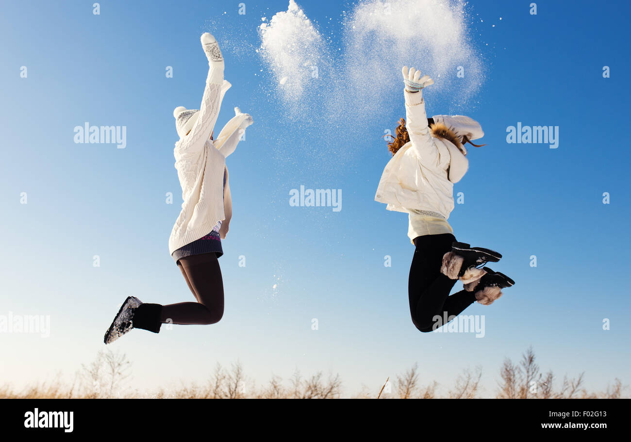 Due amiche divertirsi e godere la neve fresca in un bel giorno di inverno Foto Stock