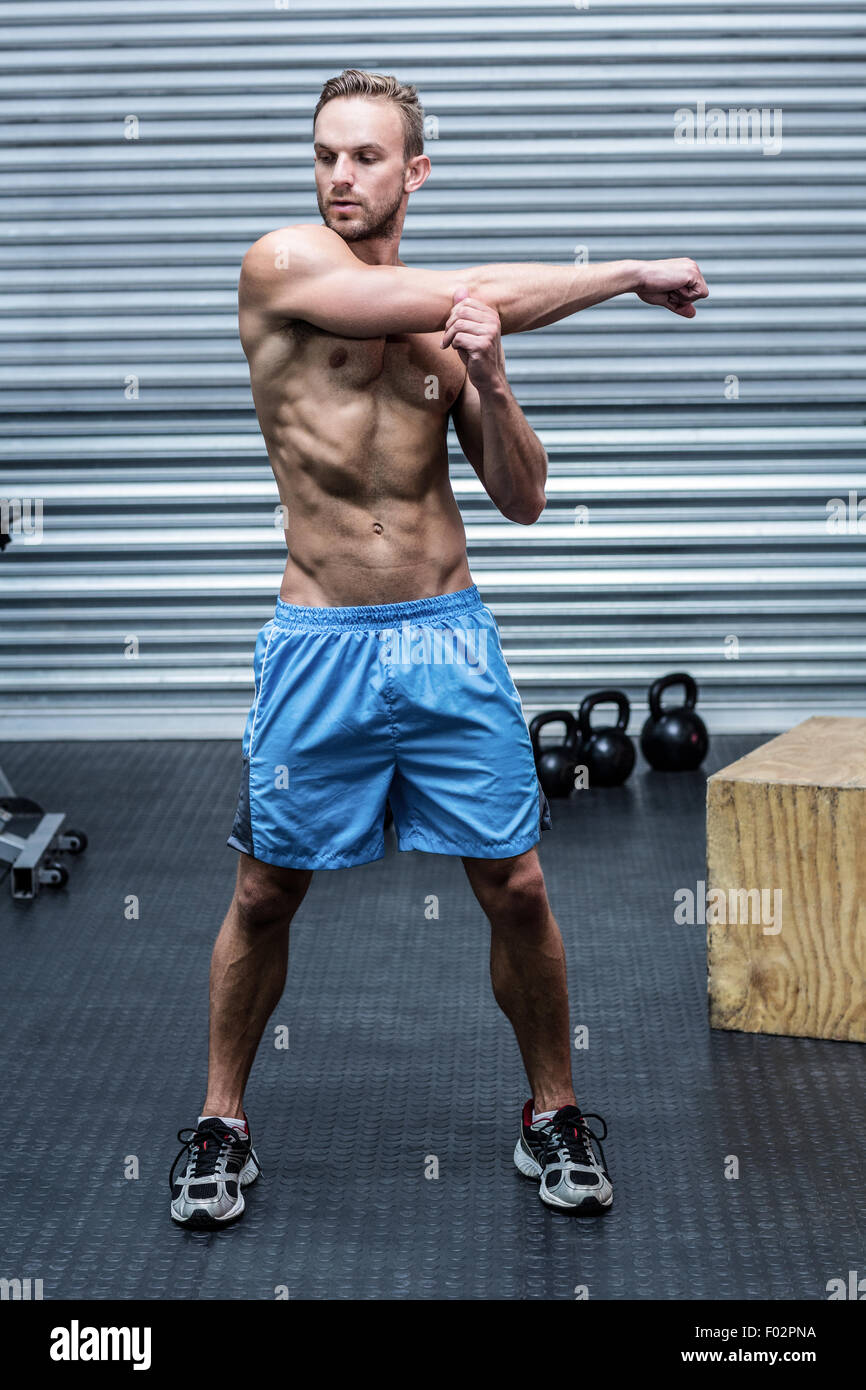 Uomo muscolare facendo stretchings braccio Foto Stock