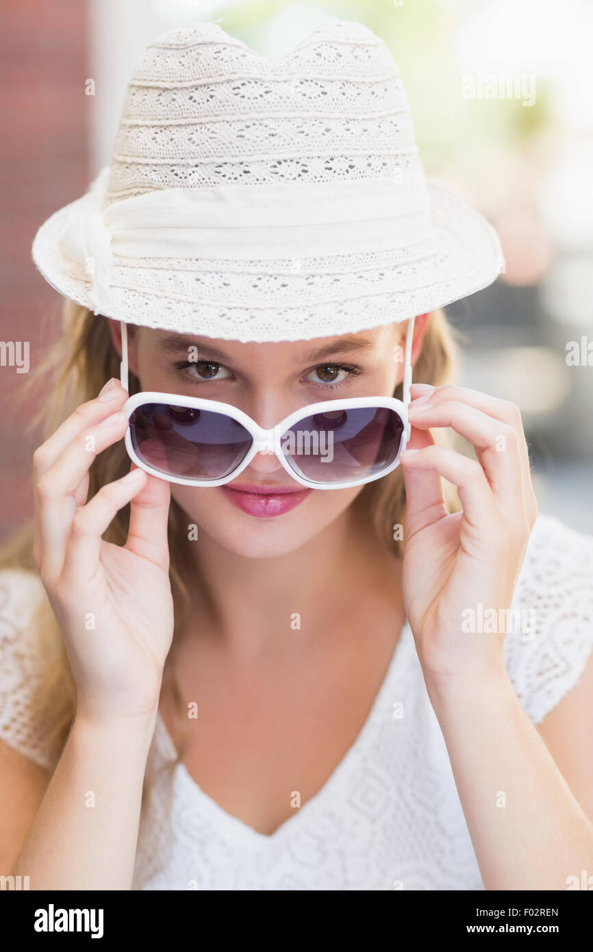 Pretty Woman inclinando i suoi occhiali da sole Foto Stock