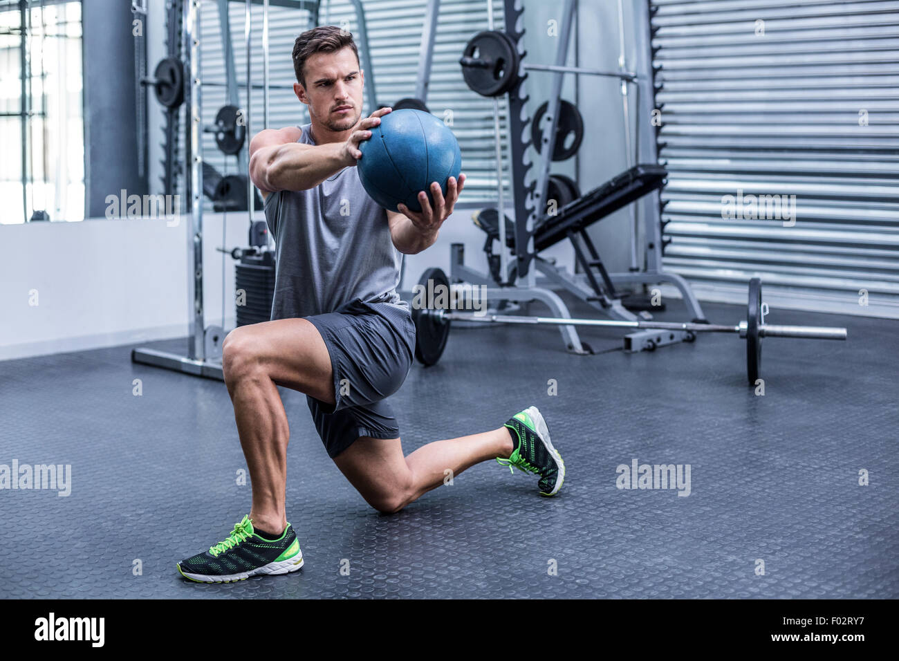 Uomo muscolare facendo medecine esercizi a sfera Foto Stock