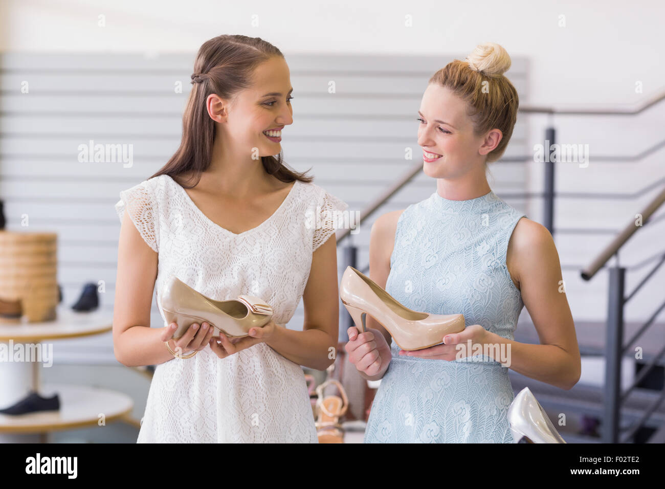 Due felici donne azienda scarpe a tacco Foto Stock