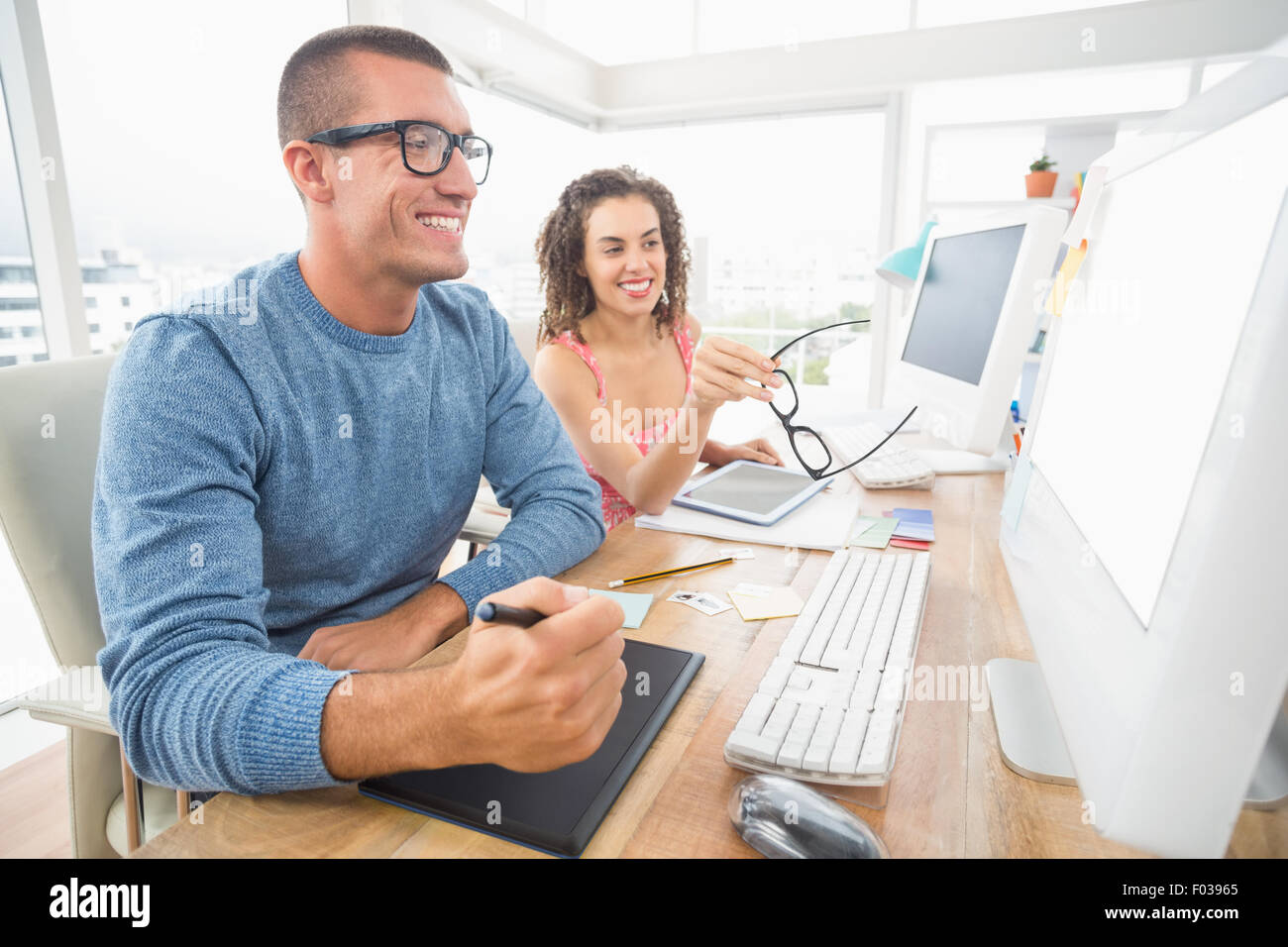 Concentrato i suoi collaboratori utilizzando laptop e il digitalizzatore Foto Stock