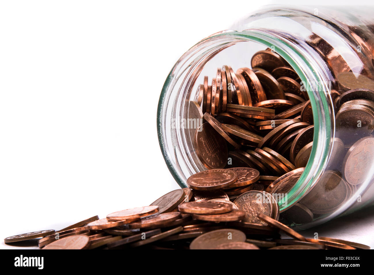 British un penny monete fuoriuscita da un vaso di vetro Foto Stock
