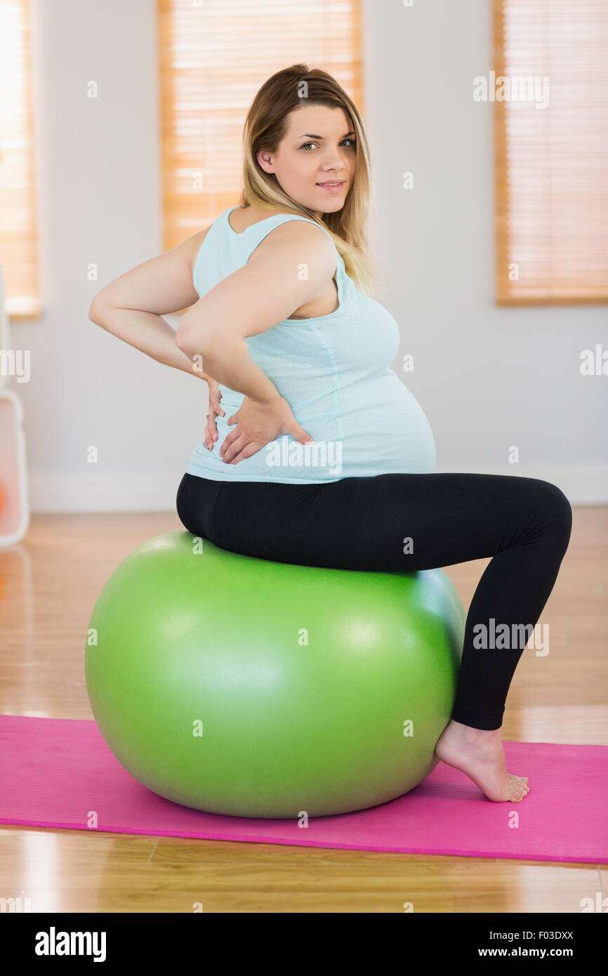 Ritratto di donna incinta seduta su palla ginnica Foto Stock