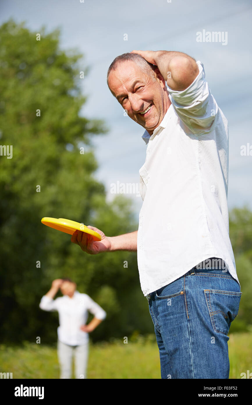 Coppia senior riproduzione di Frisbee in natura in estate Foto Stock
