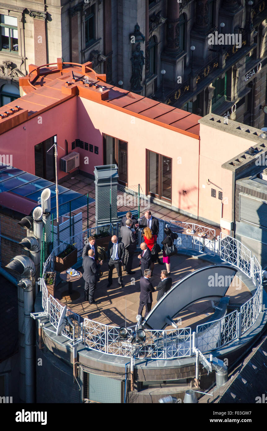 Gruppo di persone in giacca avente una riunione in una terrazza a Vienna. Foto Stock