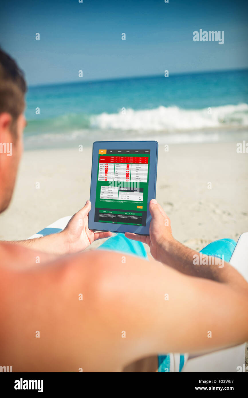 Immagine composita di uomo con tavoletta digitale sulla sedia a sdraio in spiaggia Foto Stock