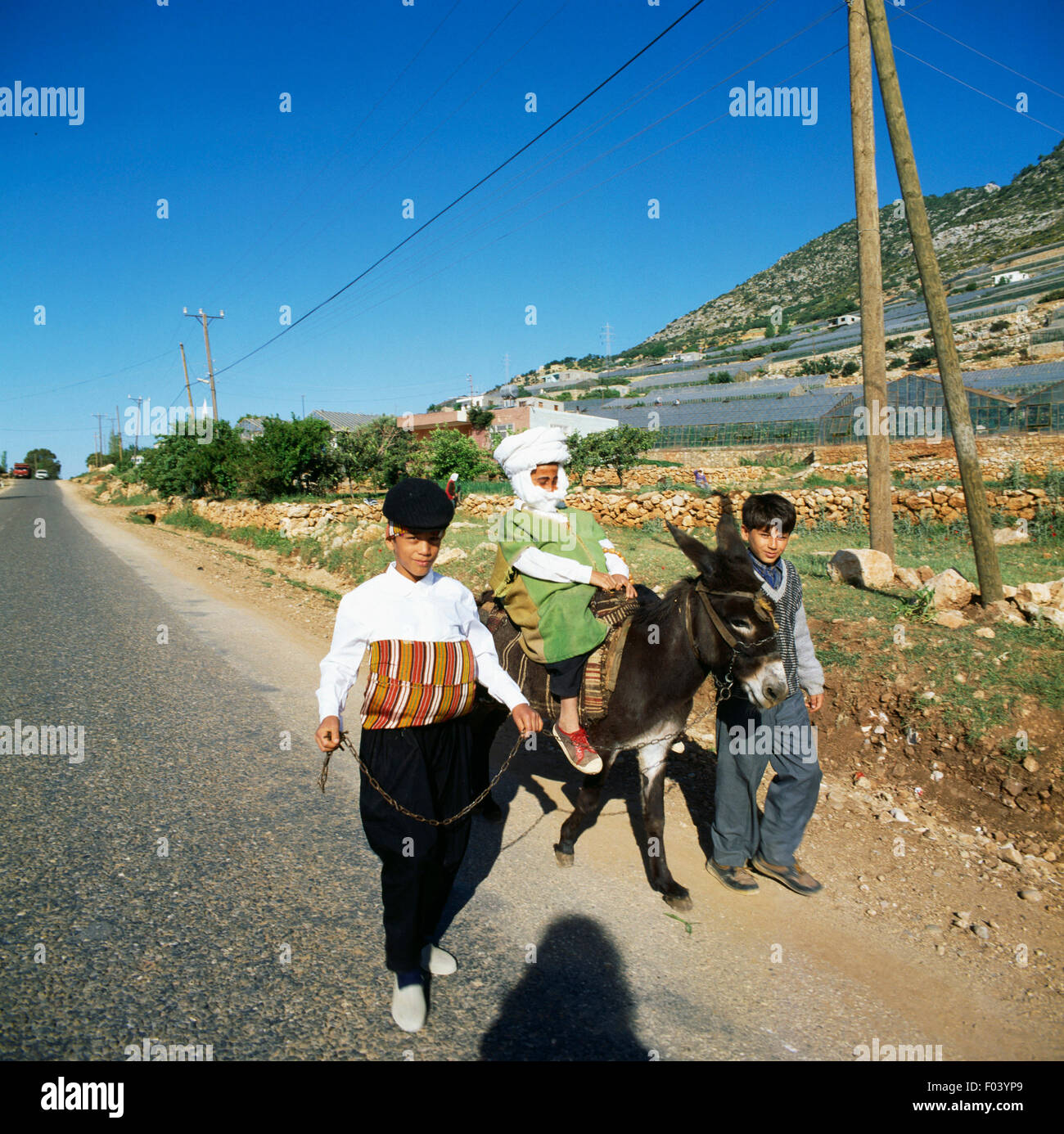 I bambini in abiti tradizionali con un asino, Yilanlikale, Turchia. Foto Stock
