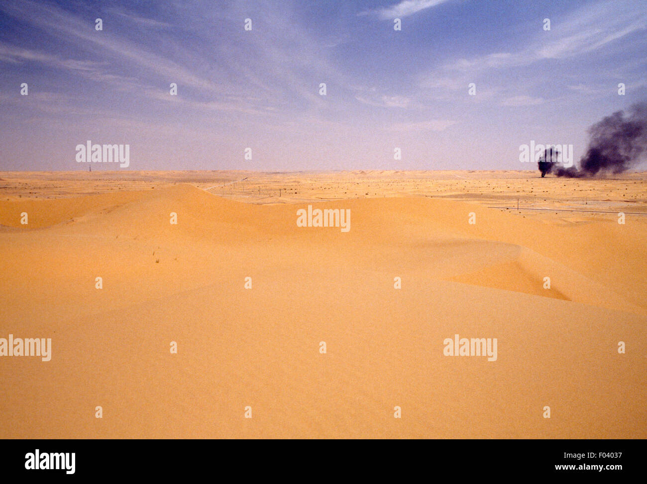 Il deserto del Sahara nei pressi di Hassi Messaoud, con un pozzo di petrolio in background, Algeria. Foto Stock