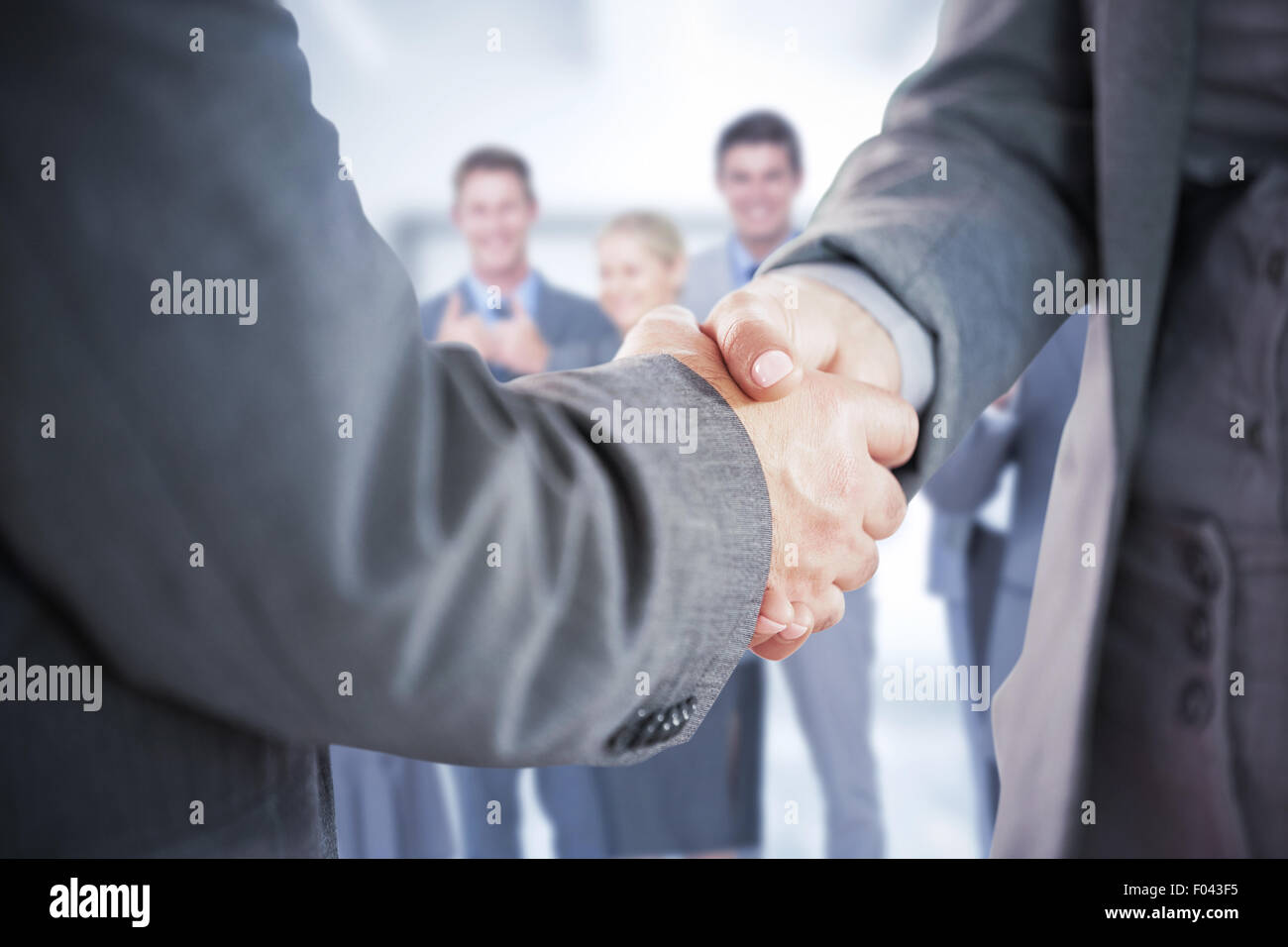 Immagine composita di uomini di affari che stringono le mani vicino fino Foto Stock