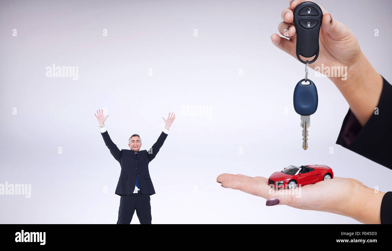 Immagine composita della donna in possesso della chiave e la piccola auto Foto Stock