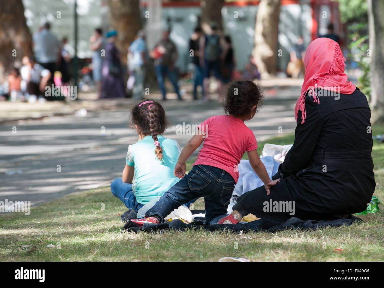 Berlino, Germania. Il 6 agosto, 2015. Un rifugiato e i suoi bambini seduti fuori la Landesamt fuer Gesundheit und Soziales (lit. Berlino agenzia di stato per la tutela della salute e degli affari sociali) di Berlino, Germania, 6 agosto 2015. Foto: PAOLO ZINKEN/DPA/Alamy Live News Foto Stock