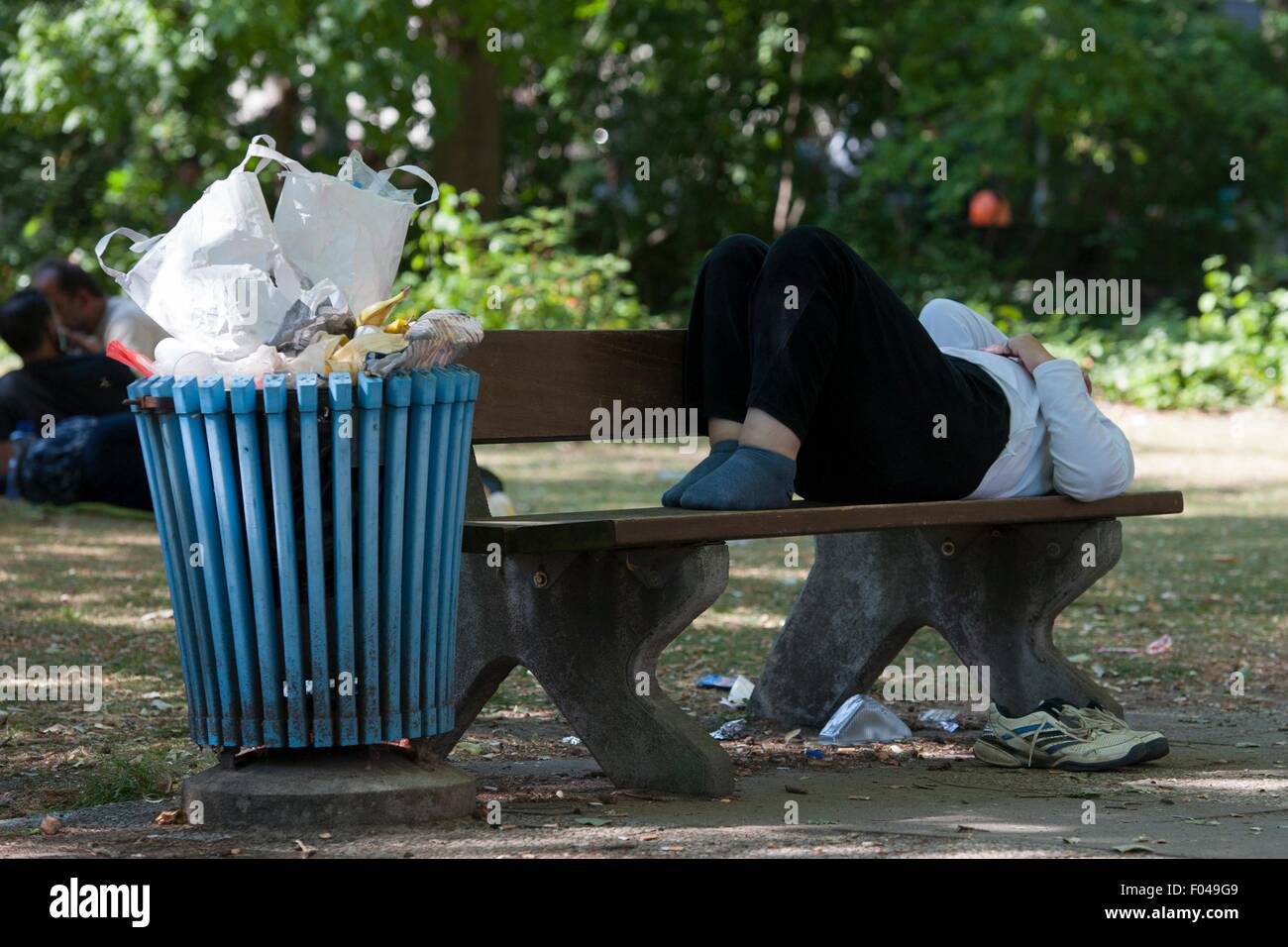 Berlino, Germania. Il 6 agosto, 2015. Un rifugiato giace su una panchina nel parco al di fuori del Landesamt fuer Gesundheit und Soziales (lit. Berlino agenzia di stato per la tutela della salute e degli affari sociali) di Berlino, Germania, 6 agosto 2015. Foto: PAOLO ZINKEN/DPA/Alamy Live News Foto Stock