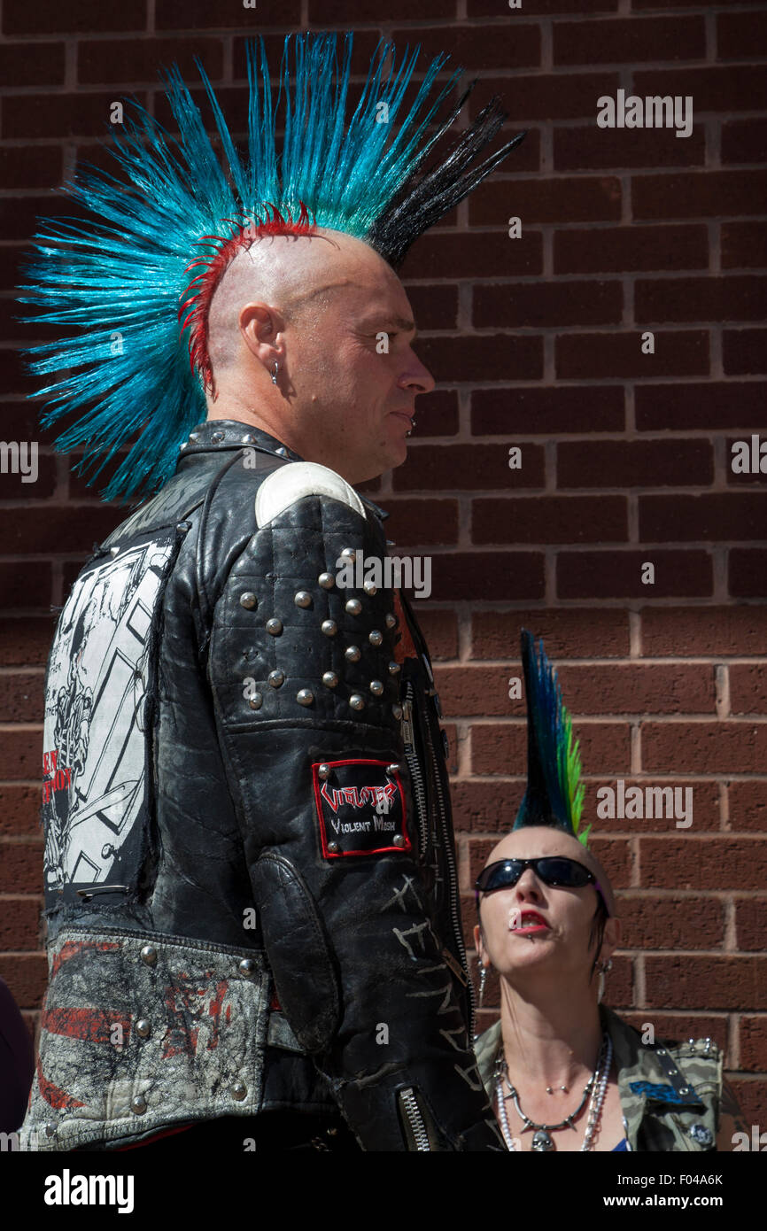 Punk con mohicano tinti mohicano acconciatura a Blackpool, Lancashire, Regno Unito. Il 7 agosto, 2015. Ribellione Punk festival presso i giardini d'inverno. Uno scontro di culture nella famosa località balneare di Blackpool come punks frequentando la ribellione annuale festival presso i Giardini Invernali venite a spalla a spalla con i vacanzieri tradizionali. Credito: MediaWorldImages/Alamy Live News Foto Stock