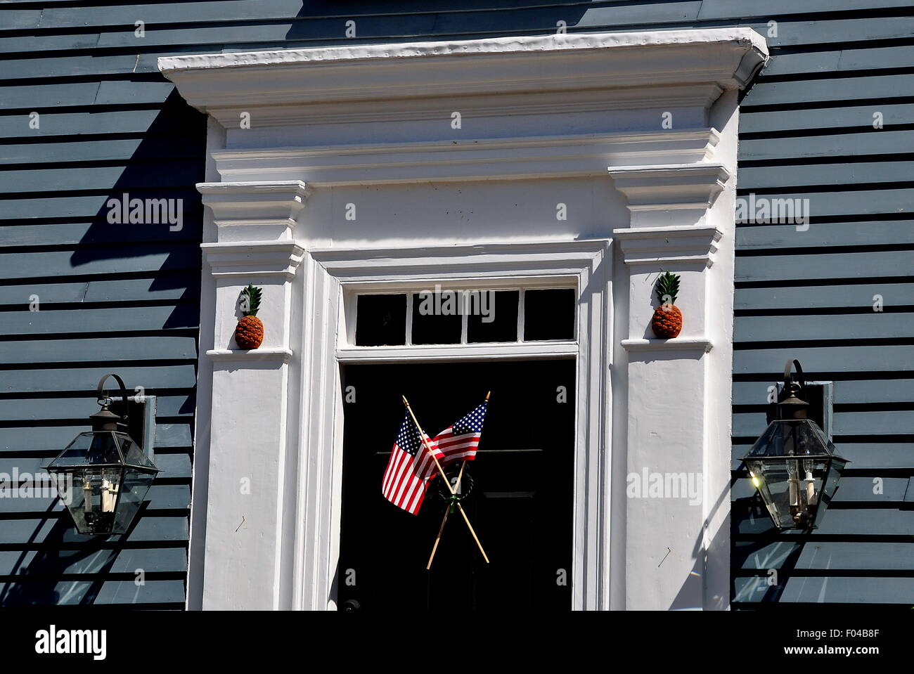 Newport, RI: Porta su Easton punto della casa coloniale con doppio bandierine americane e legno intagliato ananassi di benvenuto Foto Stock