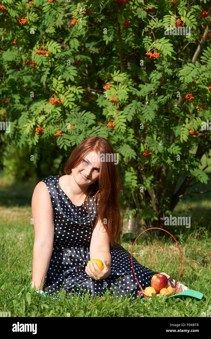 La ragazza con i capelli rossi ha picnic nel parco Foto Stock