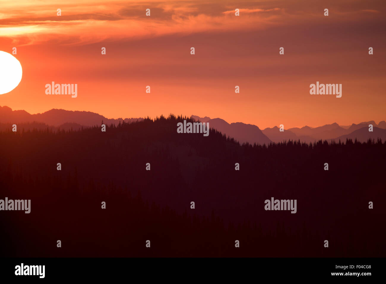 Blazing Cielo di tramonto sulle montagne, con sun di Orb Foto Stock