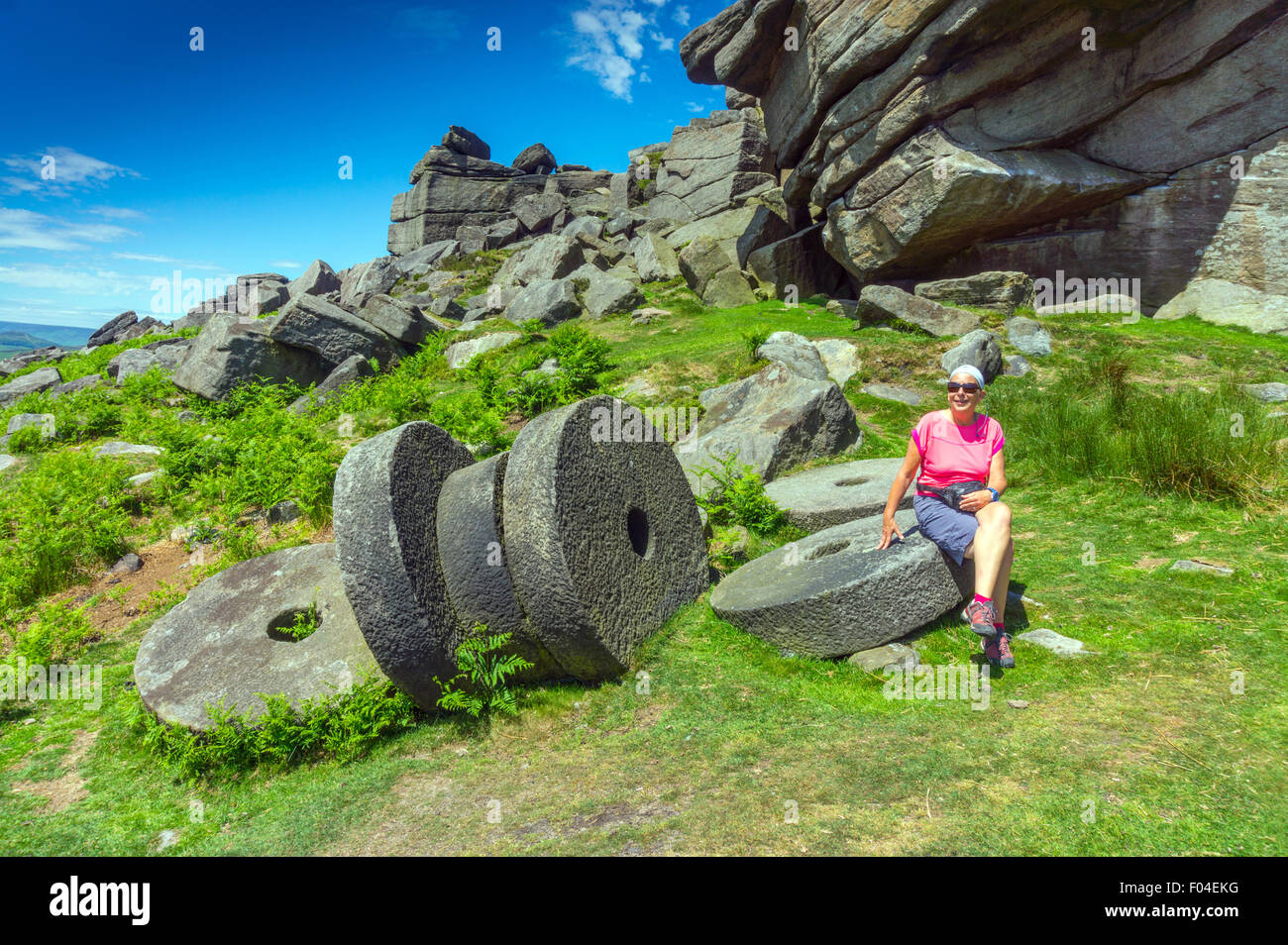 Macine abbandonate, Stanage Edge, Peak District, con femmina walker seduto Foto Stock