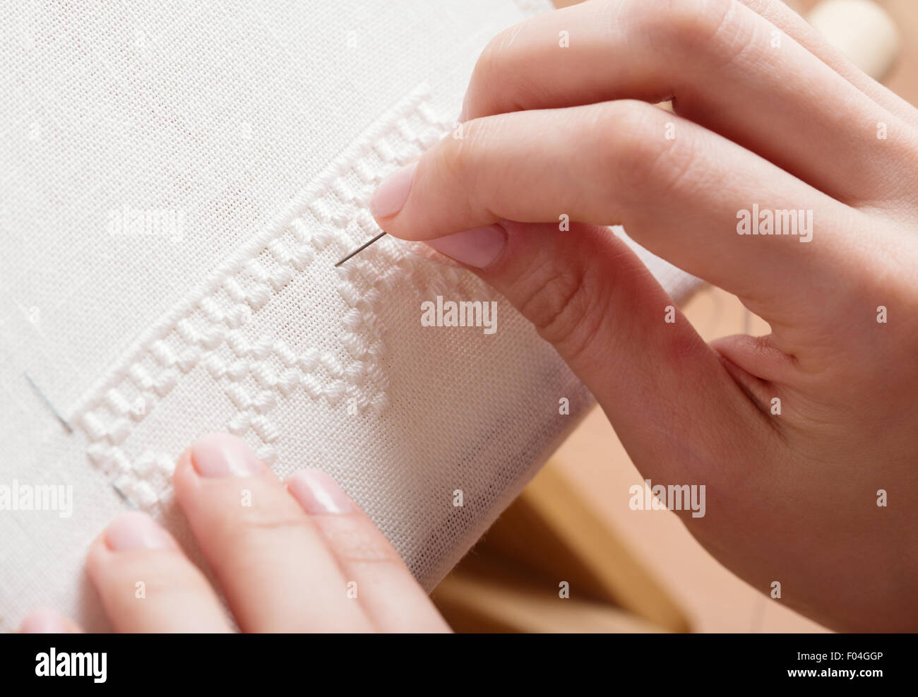 La donna le mani facendo il punto croce. Una chiusura del ricamo. Foto Stock