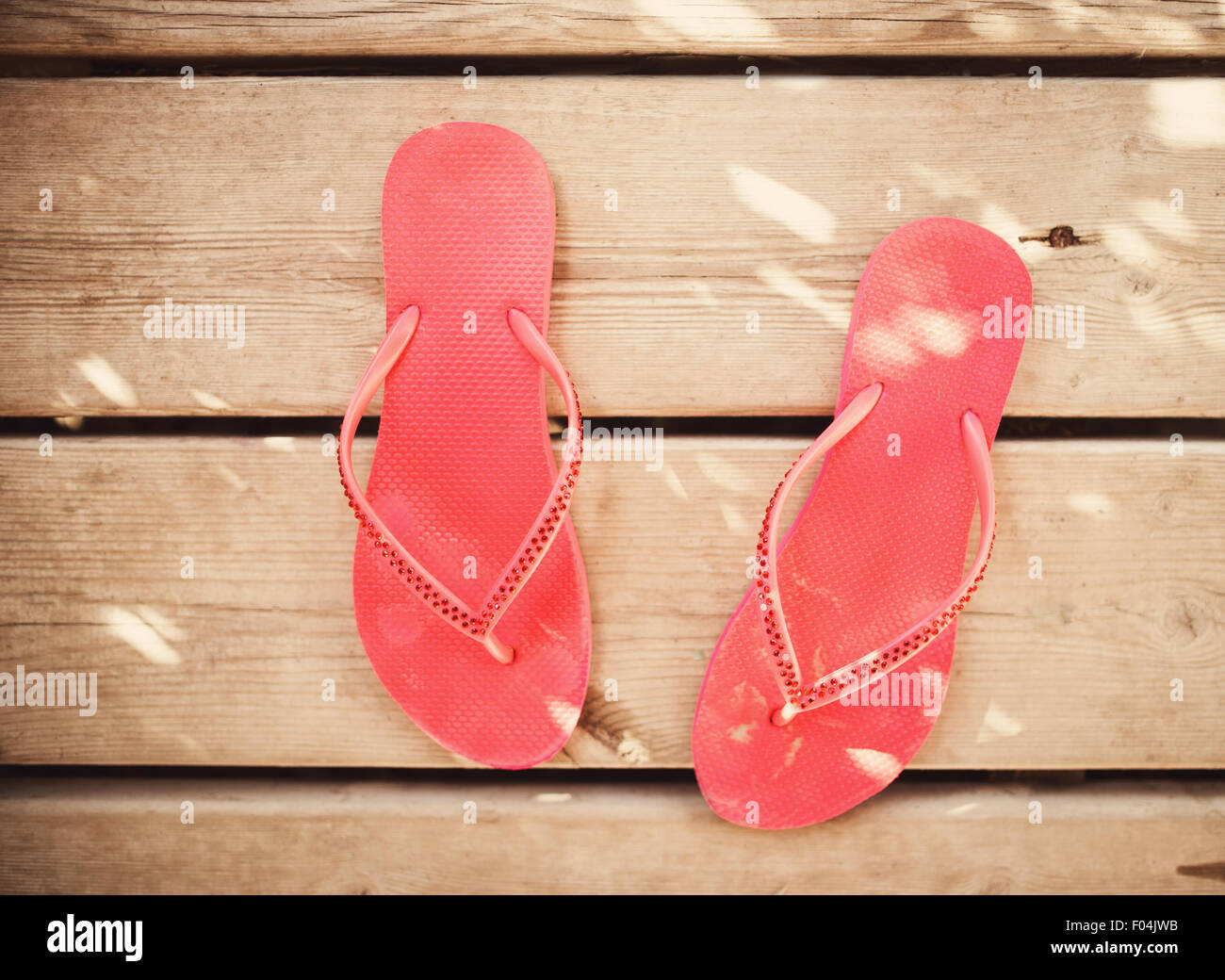 Rosa flip flop sandali su uno sfondo di legno Foto Stock