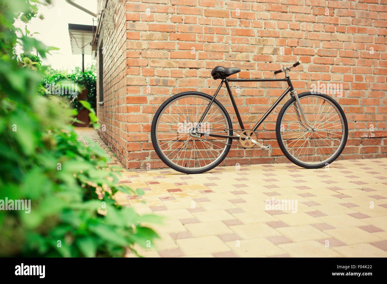 Il vecchio stile singlespeed bicicletta contro un muro di mattoni, foto oscurata Foto Stock