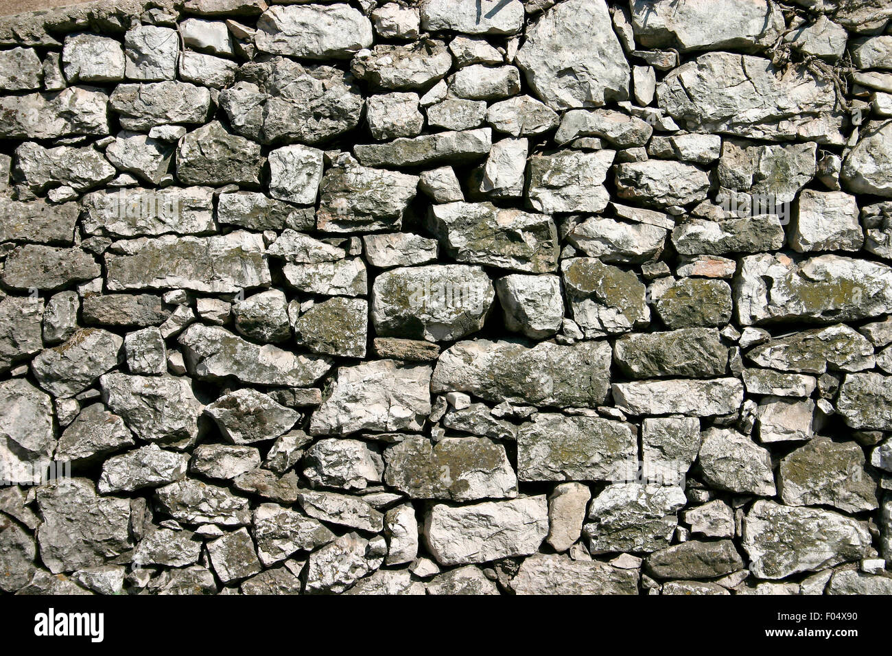 Rustico in pietra a parete con forti divari tra le pietre Foto Stock