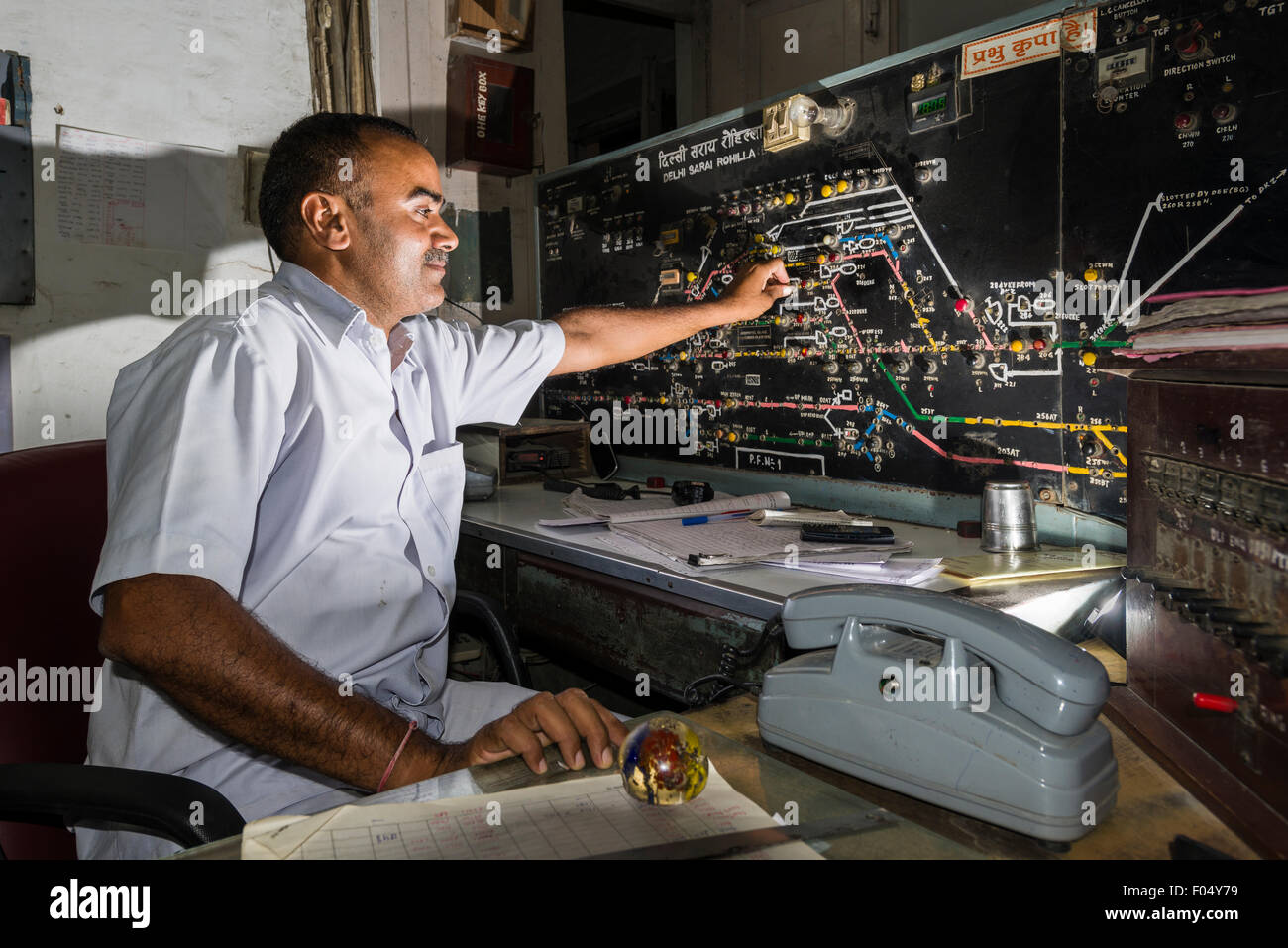 Un lavoratore è coordinare i treni in arrivo ed in partenza dalla Stazione Ferroviaria Delhi Sarai Rohilla a mano, New Delhi, Delhi Foto Stock