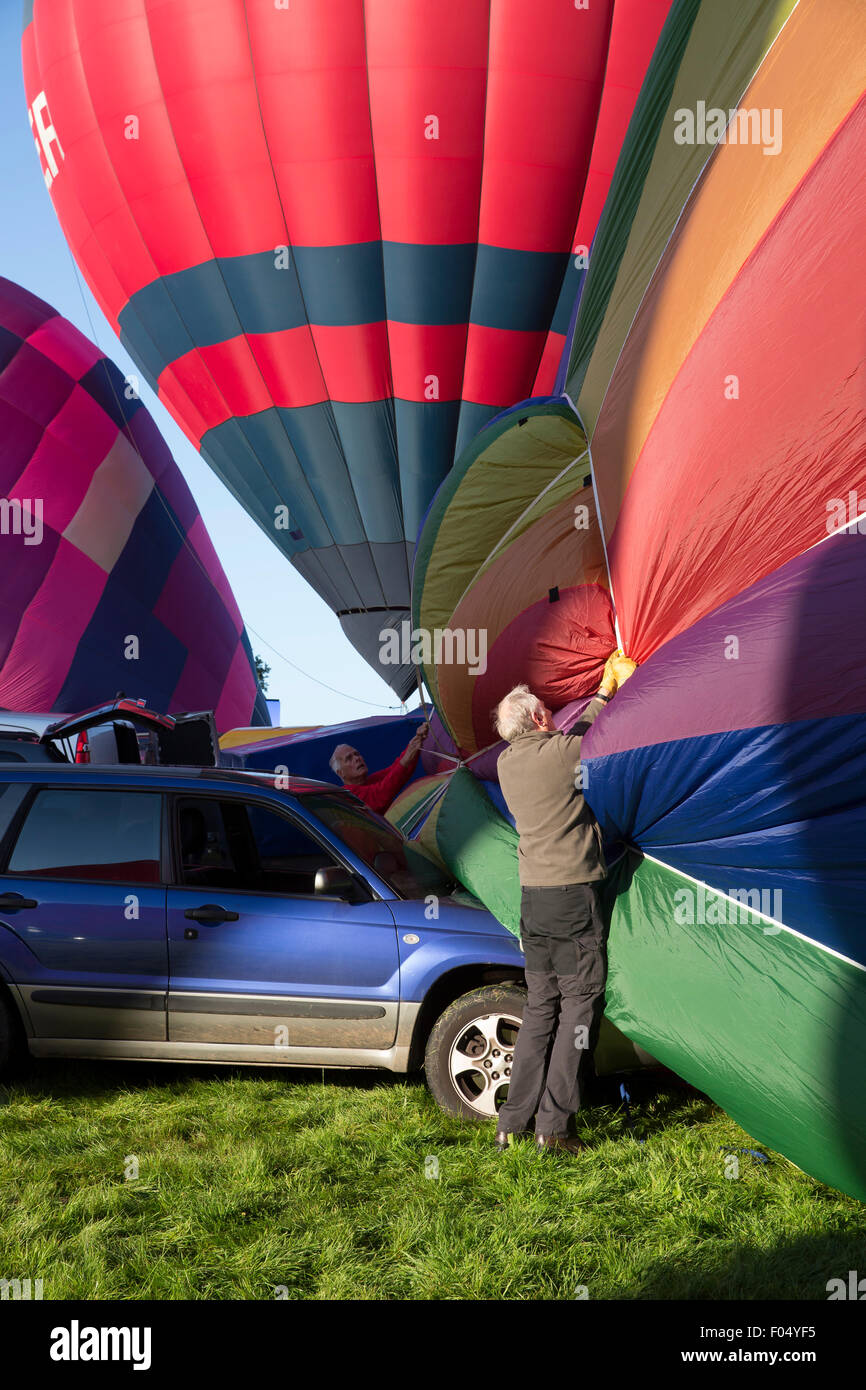 Ashton Court, Bristol, Regno Unito. 07 Ago, 2015. Due uomini battaglia con un palloncino di interrompere lo strappo sulla vettura come la mattina presto l'inflazione inizia a Bristol International Balloon Fiesta 2015. Credito: Keith Larby/Alamy Live News Foto Stock