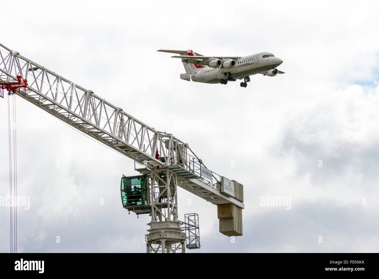 Cityjet Dornier 328-110 in atterraggio a City Airport London dietro di gru a torre galeoni a raggiungere lo sviluppo, Docklands Foto Stock