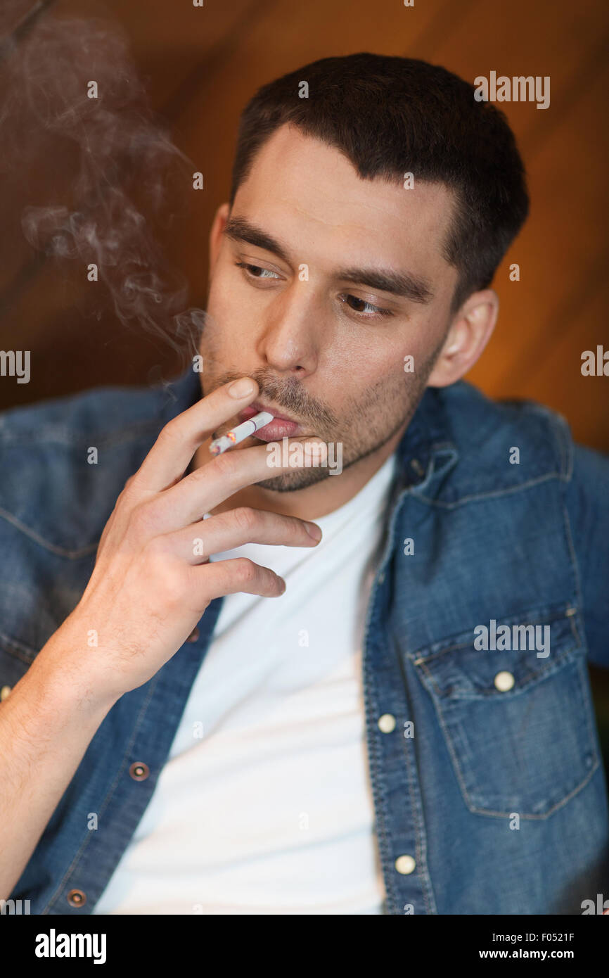 Giovane uomo Sigaretta fumare al bar Foto Stock
