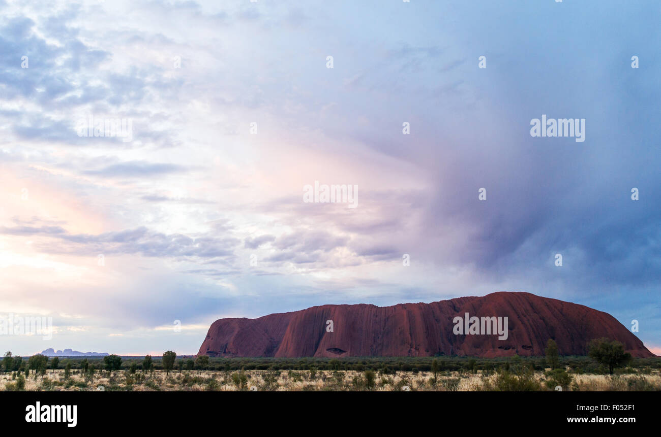 Australia, Ayers Rock, nuvoloso tramonto su Uluru la montagna sacra Foto Stock