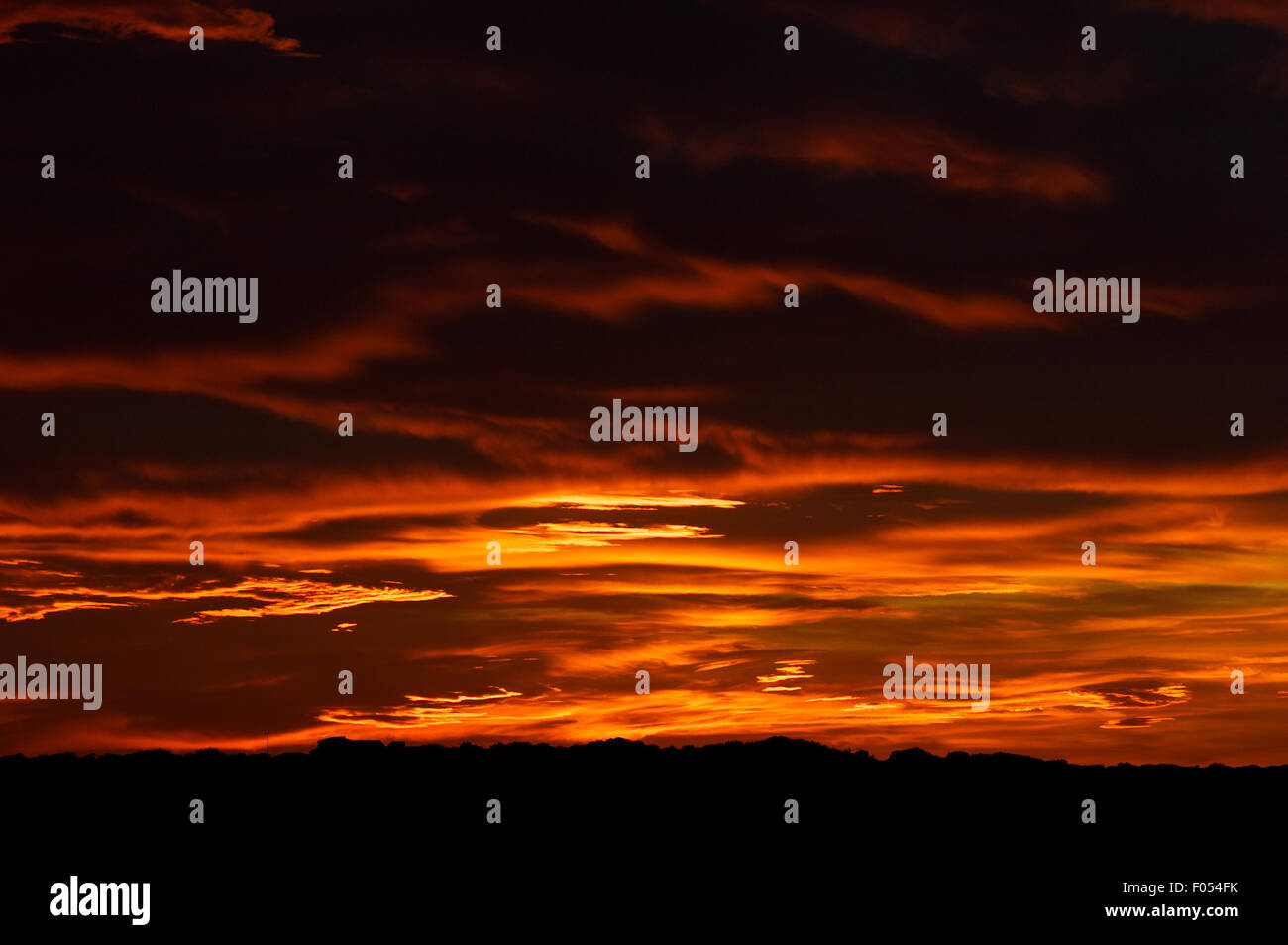 Nuvole rosse al tramonto come un cielo ardente di un tramonto spettacolare da la Savina (Formentera, Isole Pityusic, Isole Baleari, Spagna) Foto Stock