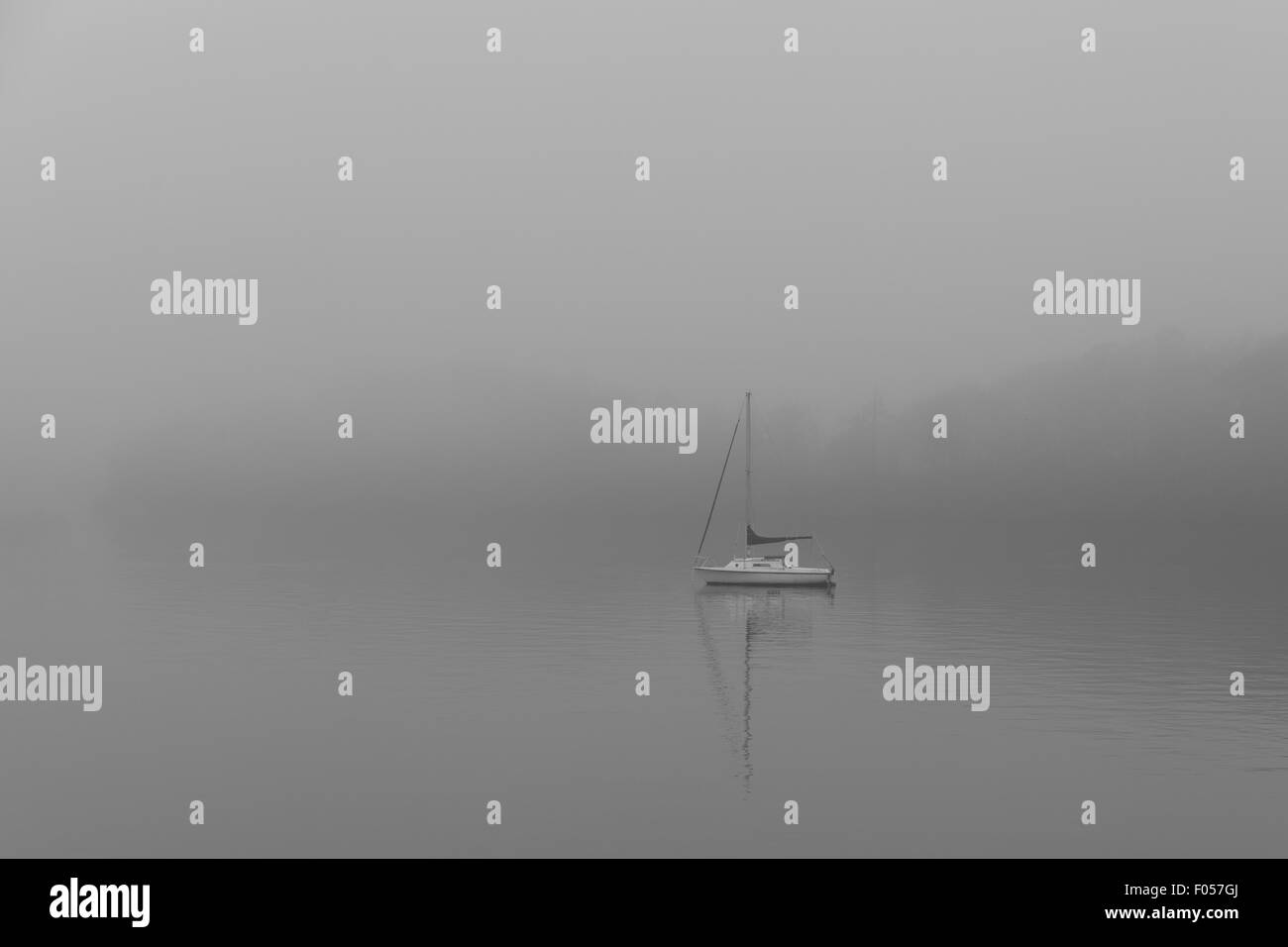 Barca su un lago di nebbia Foto Stock