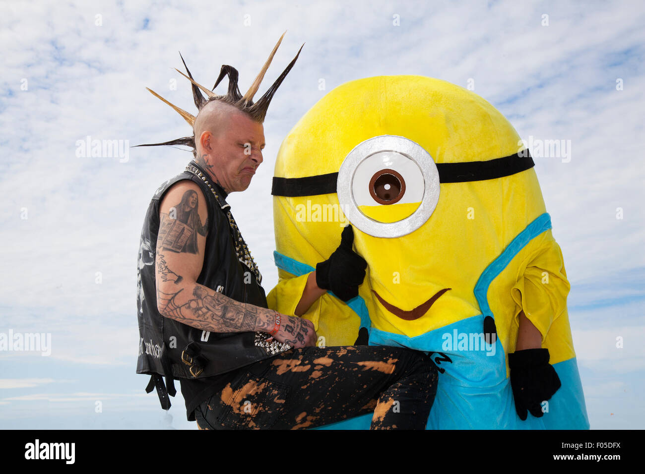 Punk con mohicano tinti mohicano acconciatura a Blackpool, Lancashire, Regno Unito. Il 7 agosto, 2015. Tim Hellstrom da Holland odia i Minion alla ribellione Punk festival presso i giardini d'inverno. Uno scontro di culture nella famosa località balneare di Blackpool come punks frequentando la ribellione annuale festival presso i Giardini Invernali venite a spalla a spalla con i vacanzieri tradizionali. Credito: MediaWorldImages/Alamy Live News Foto Stock