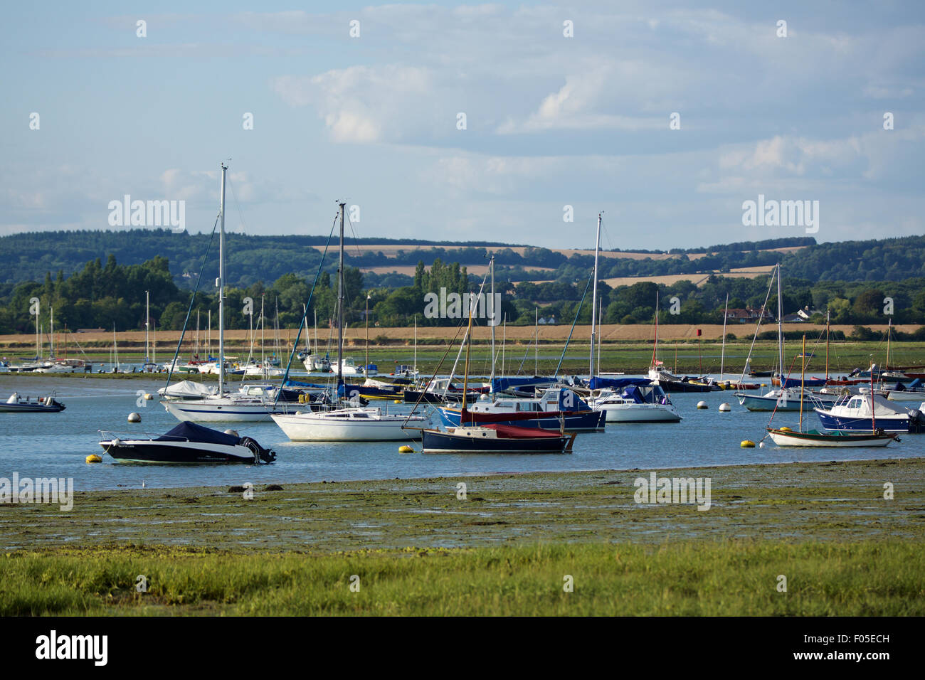 Porto di Chichester vicino a Bosham nel Sussex occidentale. Vista di un estuario pieno di piccole imbarcazioni che si meandri verso le colline lontane. Foto Stock