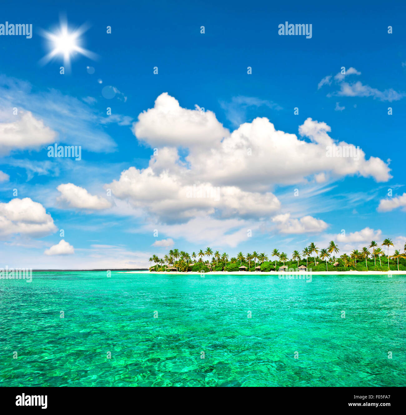 Paesaggio di isola tropicale spiaggia con palme sole e cielo blu Foto Stock