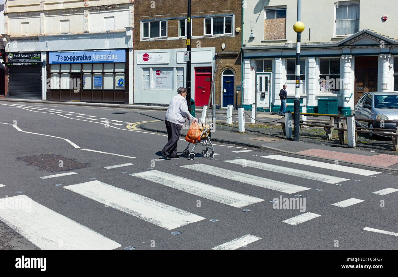 Oldbury, persona vecchia strada di attraversamento Foto Stock