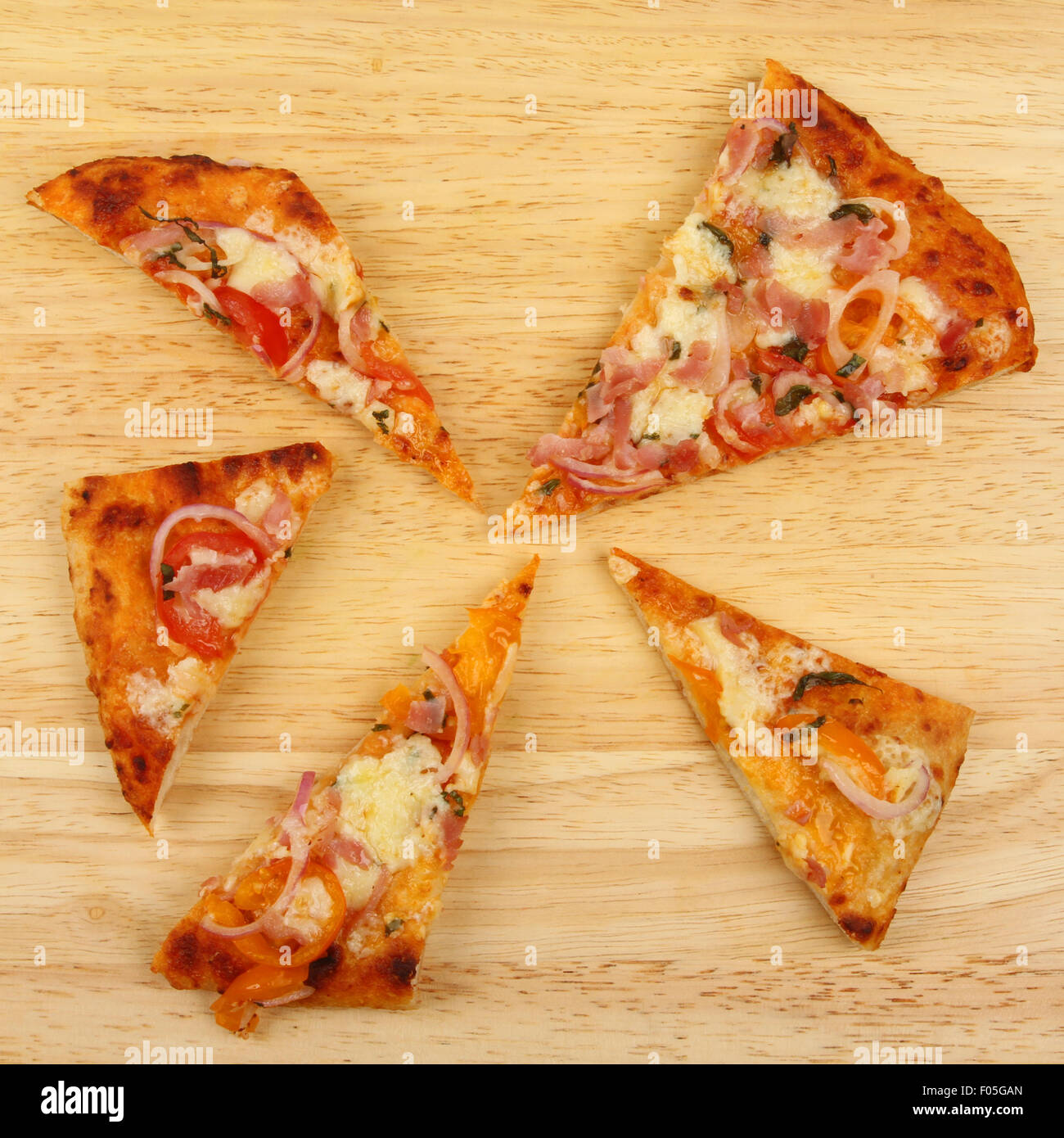 Triangolare di fette di pizza su una tavola di legno, formato quadrato Foto Stock