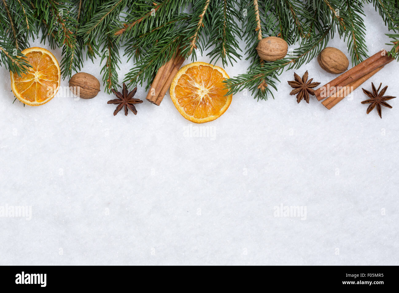 Sfondo di natale decorazione con rami di abete, frutti di colore arancione e neve Foto Stock