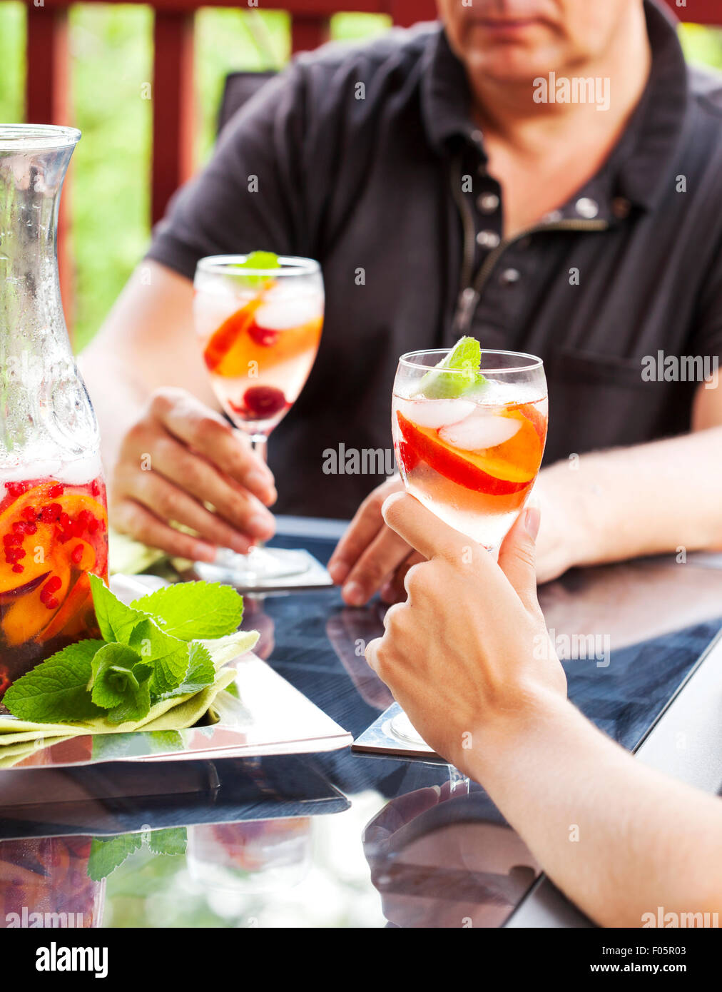 Giovane bere sangria in bianco. La sangria bianca con frutti e bacche. Foto Stock