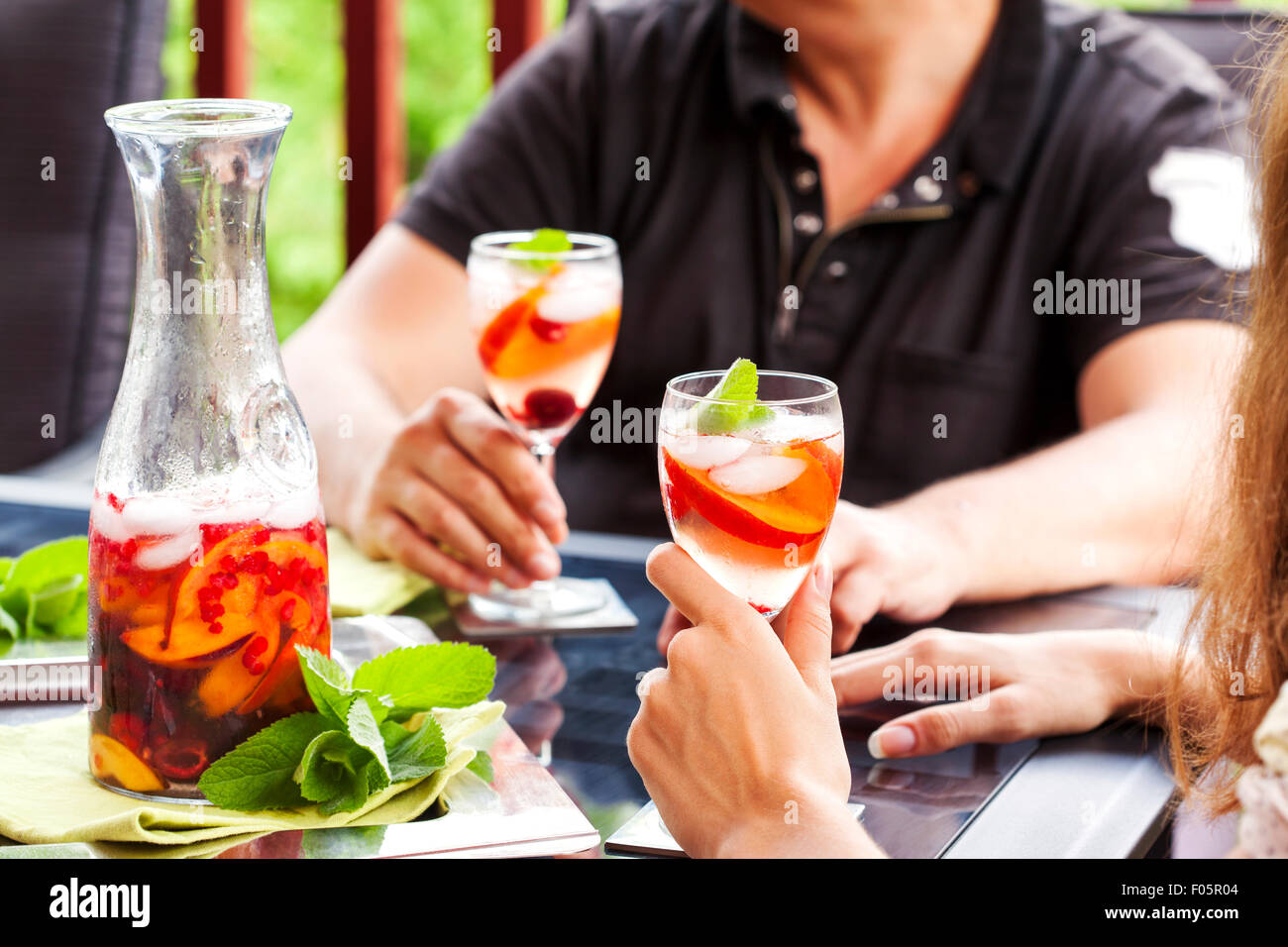 Giovane bere sangria in bianco. La sangria bianca con frutti e bacche. Foto Stock