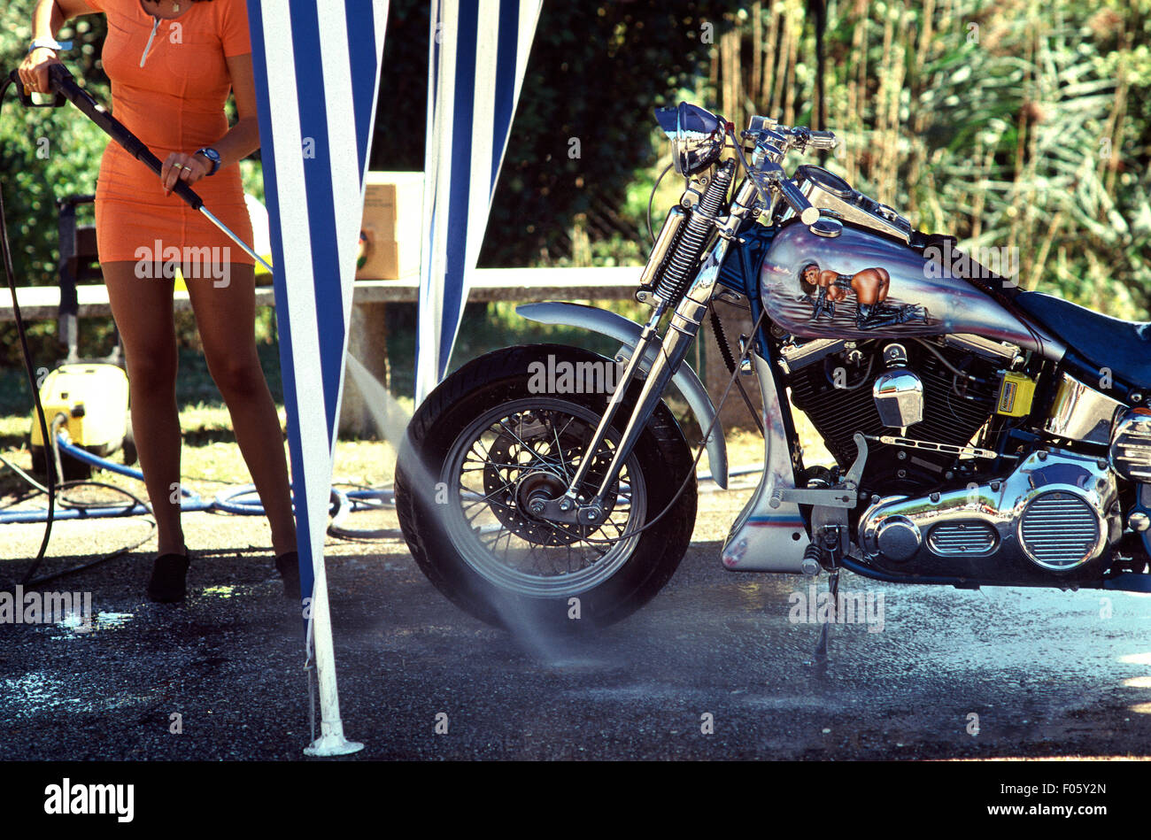 Donna di lavaggio di un motociclo. Foto Stock