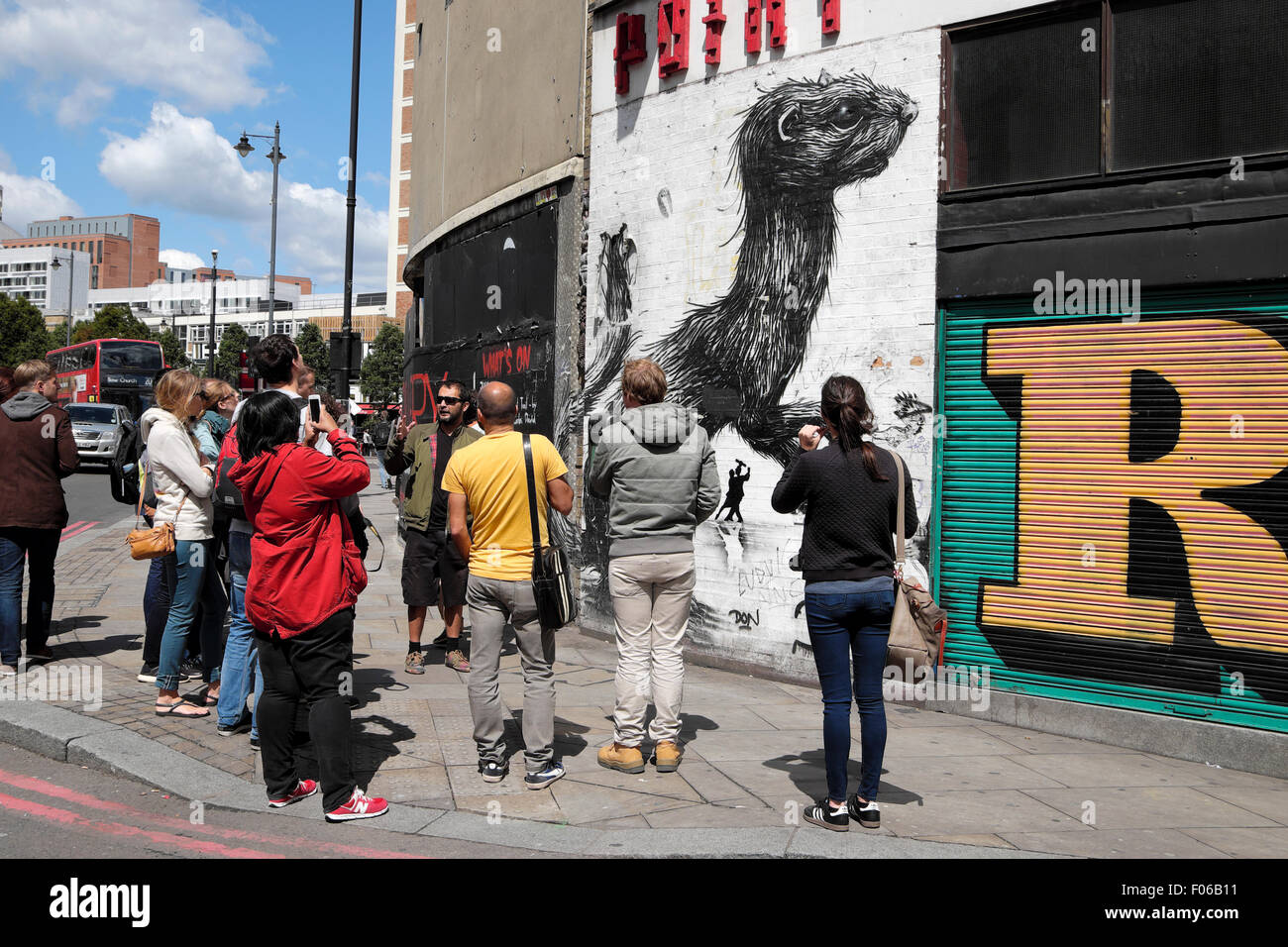 Arte di strada tour di gruppo guida e guardando a graffiti su un muro vicino Rivington Street nella zona est di Londra UK KATHY DEWITT Foto Stock