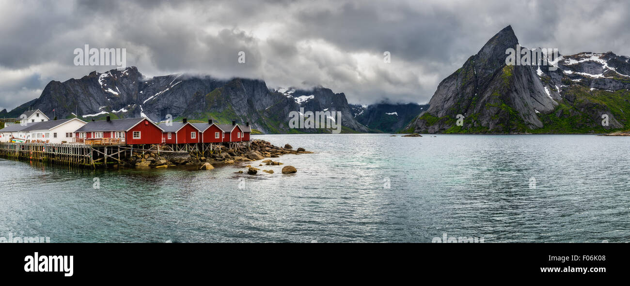 Panorama del monte Olstind sopra la pesca rosso cabine denominate Rorbu nella città di Hamnoy sulle isole Lofoten in Norvegia Foto Stock