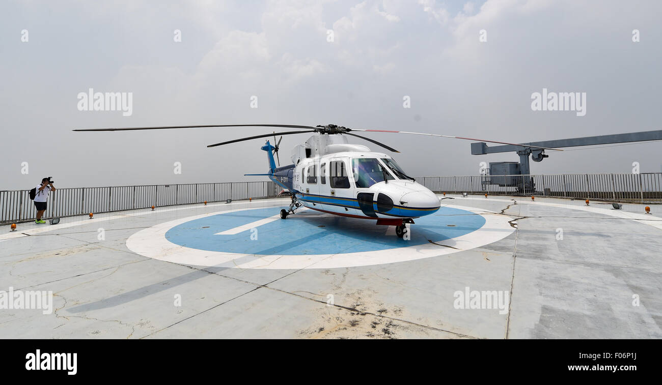 Shenzhen. Il 7 agosto, 2015. Foto scattata il 7 agosto, 2015 mostra un elicottero di Astro aria seduta parcheggiato sulla parte superiore di un edificio per uffici nel centro di Shenzhen, Cina del sud della provincia di Guangdong. Astro aria Co. Ltd. Azienda di Shenzhen il 7 agosto ha lanciato tour in elicottero su una scenografica parte della città, mentre dicendo che prevede inoltre di avviare un intercity 'flying taxi servizio'. Il tour su Nanshan District offre ai turisti una 25 minuti per 2,598 yuan (circa 418.78 dollari USA) per persona. © Mao Siqian/Xinhua/Alamy Live News Foto Stock